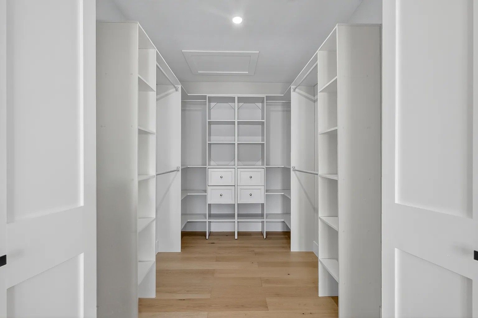 Custom white walk-in closet system with shelving and drawers in Clearwater Beach, FL