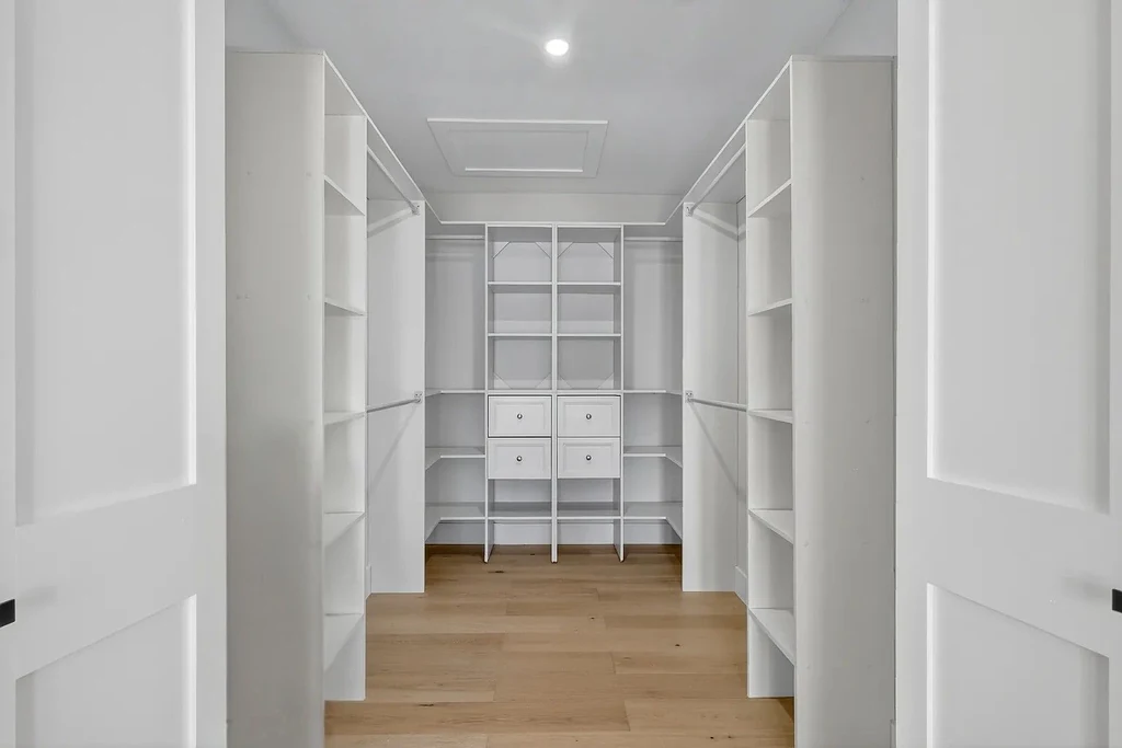 Custom white walk-in closet system installation with shelving and drawers in Clearwater Beach, FL