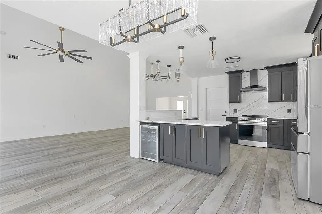 Gray wood-look porcelain tile flooring in an open kitchen with island in North Redington Beach, FL