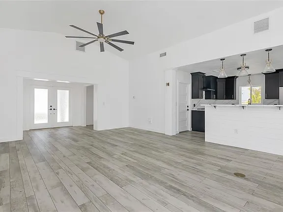 Gray wood-look porcelain tile flooring in a vaulted great room with open kitchen in North Redington Beach, FL