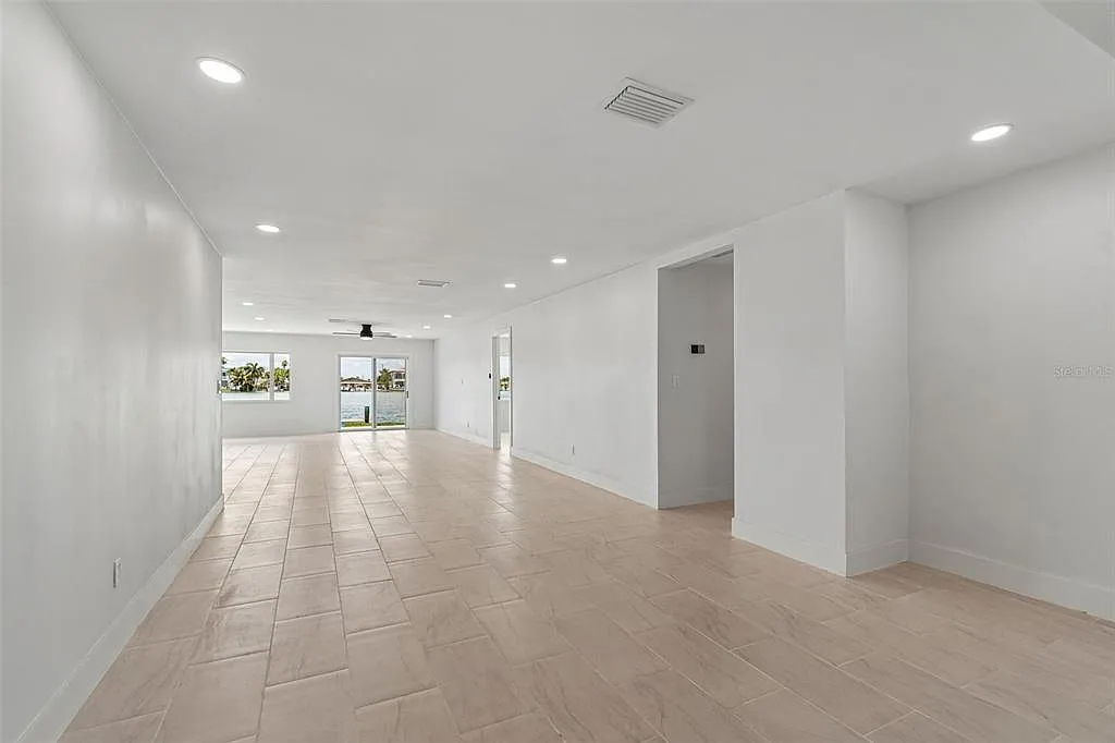 Open-concept living area with light wood-look porcelain tile flooring and a waterfront view in Treasure Island, FL